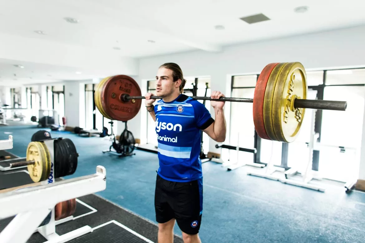 Photograph of Bath rugby player training back squat at the gym at Farleigh House shot by Paris Penny Photography