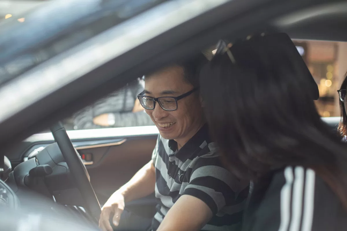 Man smiling as he is sat in a Toyota at a Toyota event - by Paris Penny photographer Bristol
